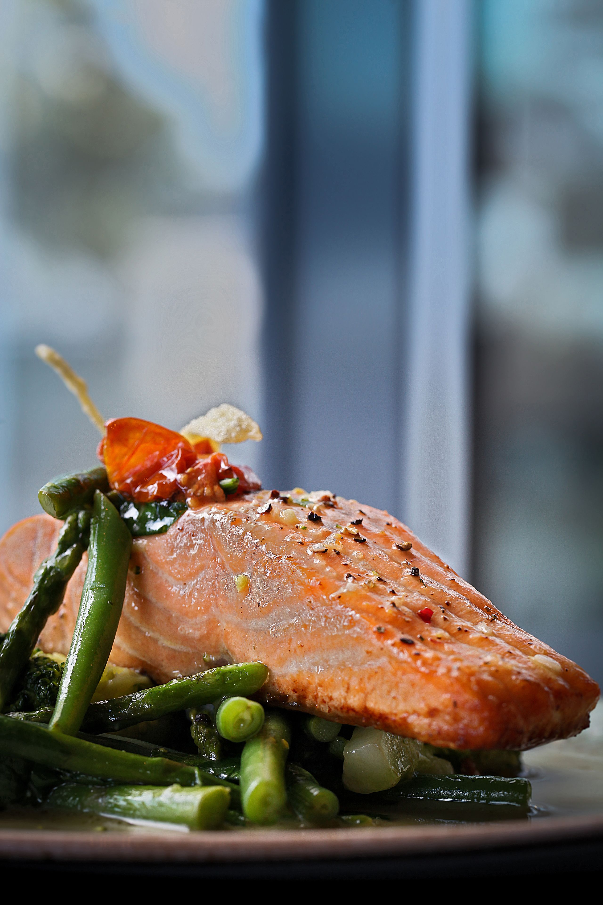 A plate of food with salmon, green beans, and peas.