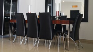 A modern dining area with a wooden table and black chairs with chrome legs. - Casa Blanca del Mar Hotel Boutique (Cartagena)