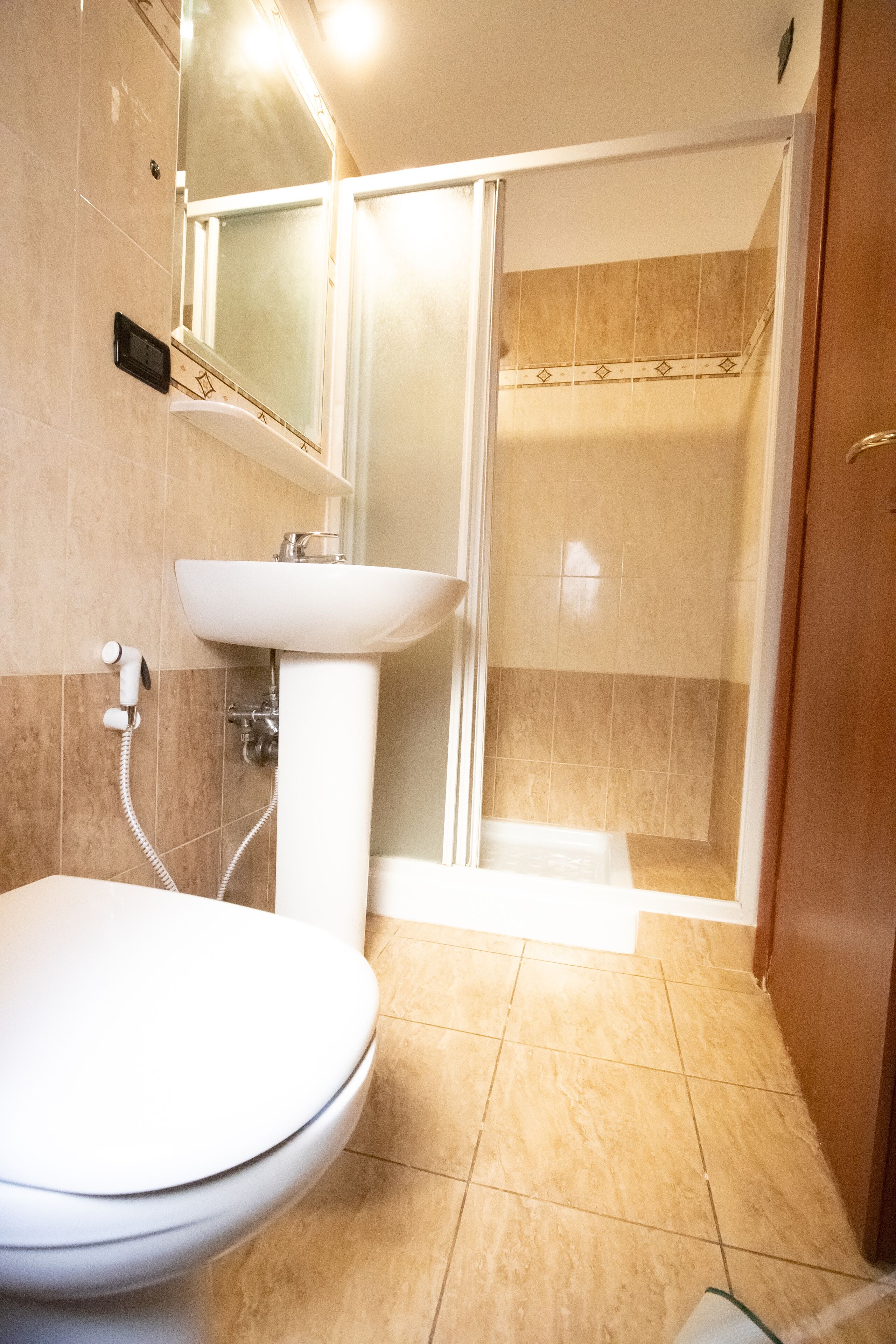 A bathroom with a toilet, sink, and shower.