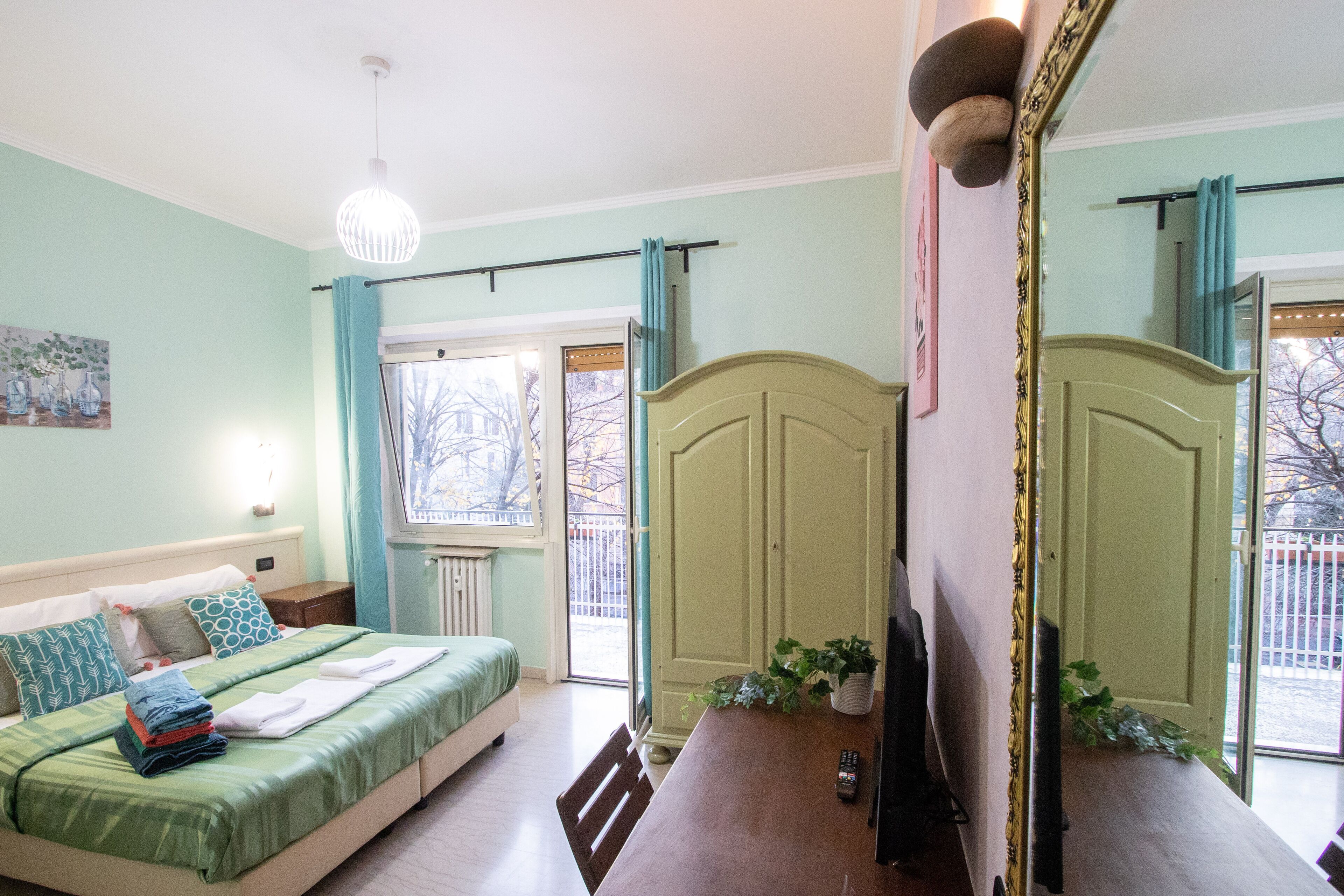 Una camera da letto con un letto, un comodino e un grande specchio.