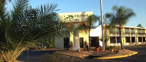 Een hotel met een bord waarop staat '3 Palm Hotels'.