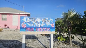 Letrero para Villa Vista Tropical, con temática de hibisco rosa.