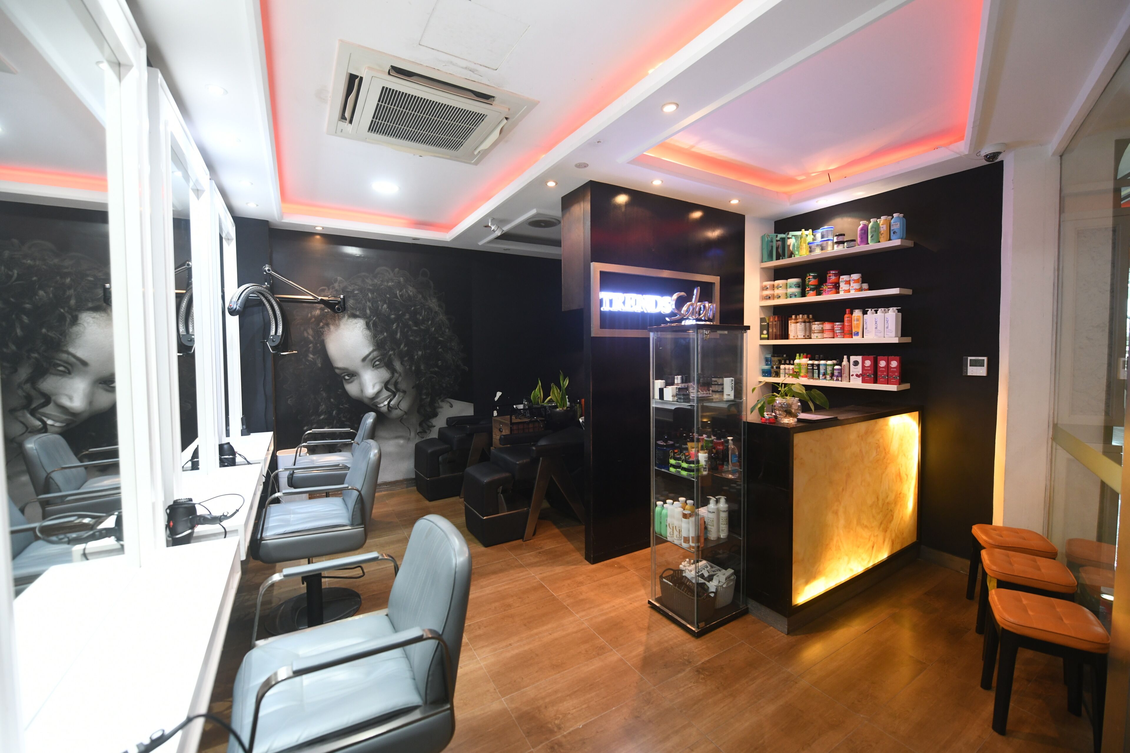 A salon with a reception desk, shelves with products, and seating areas.