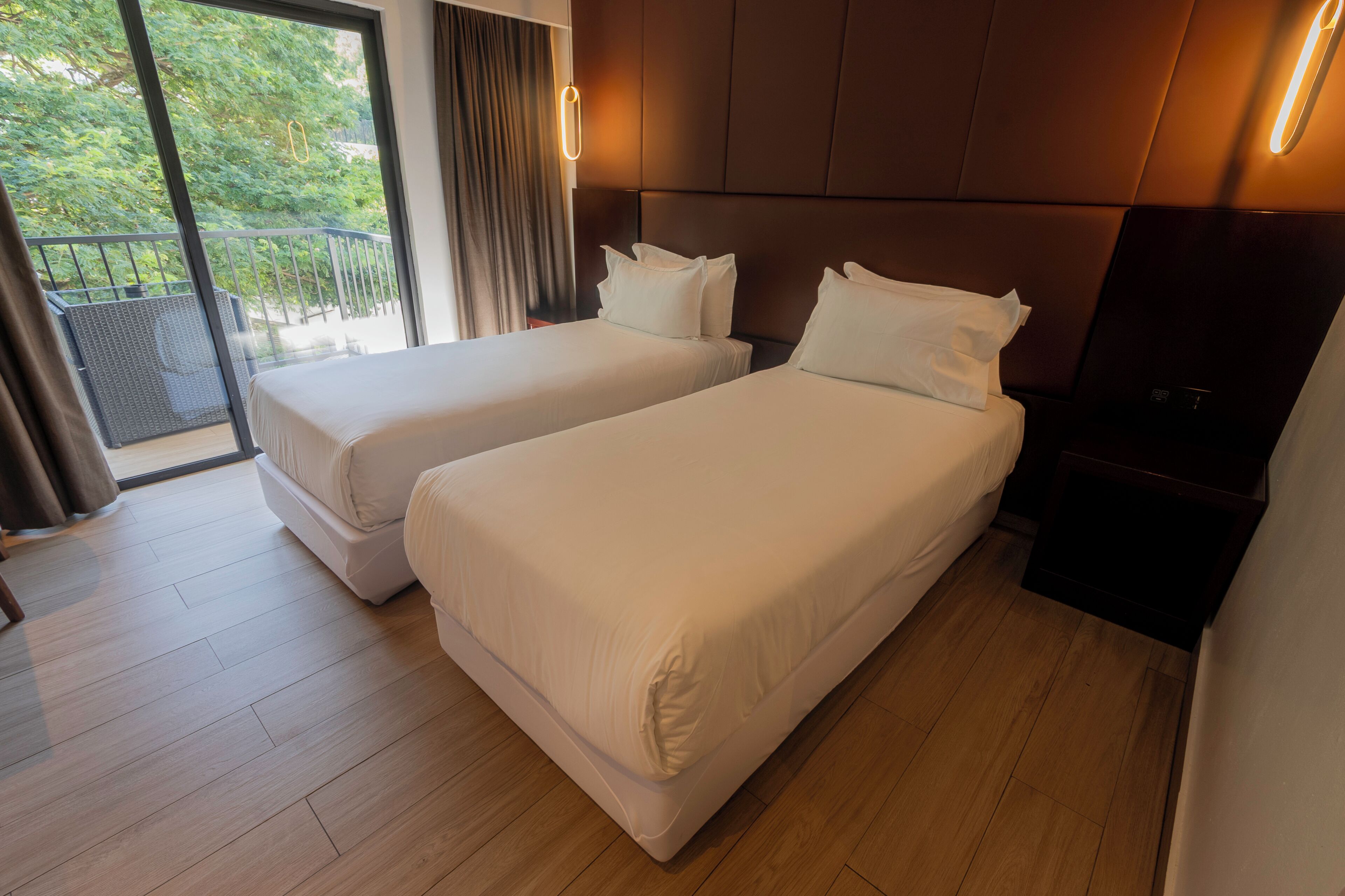 Ett hotellrum med två sängar, en balkong och en modern design.
