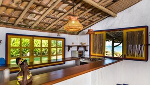 A kitchen with a wooden counter, a stove, and a hanging woven light fixture. - Enseada do Espelho (Porto Seguro)