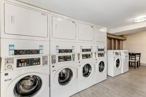 Une rangée de machines à laver empilées dans une buanderie.