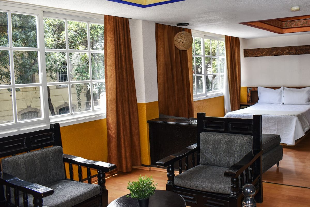 A hotel room with two beds, a desk, and a chair.