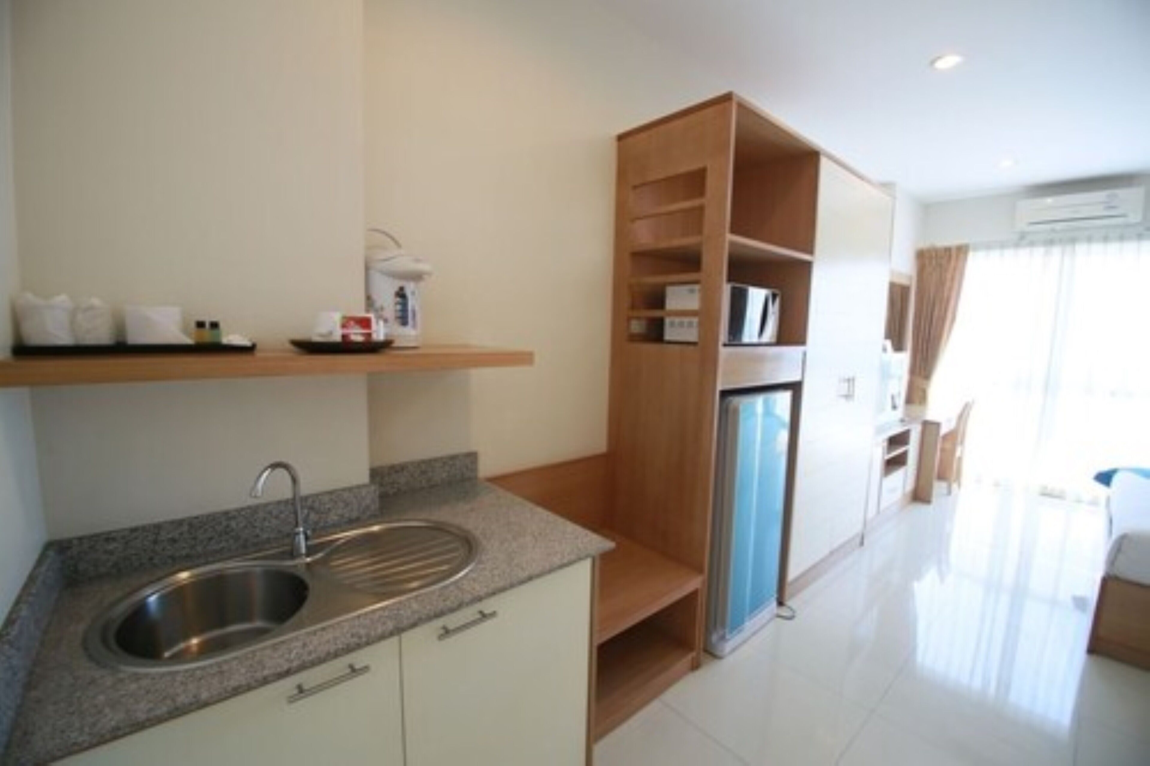 A modern kitchen with a granite countertop, stainless steel sink, and a built-in refrigerator.