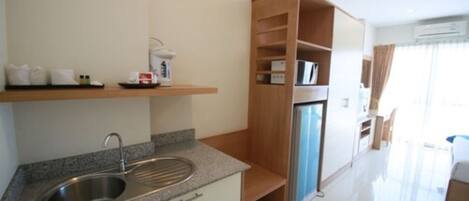 A modern kitchen with a granite countertop, stainless steel sink, and a built-in refrigerator.