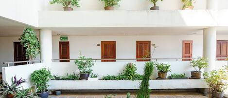 A multi-level atrium with potted plants and wooden doors.