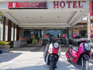The entrance to Le Desir Resort Hotel with a clear view of the facade, including the hotel name and a taxi service sign. - Le Desir Resortel (Chalong)