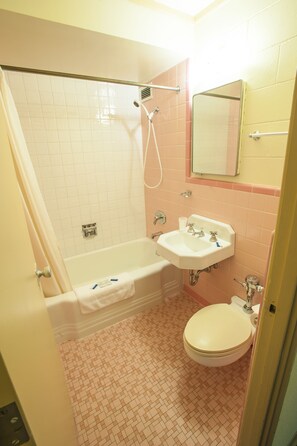 Un baño con bañera, lavamanos e inodoro.