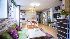 Una sala moderna con un sofá, una mesa de centro y una cocina al fondo.