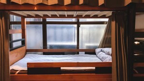 A bunk bed with a wooden frame and a window with frosted glass. - Peace House Showa - Hostel (Osaka)