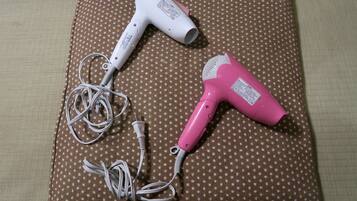 Two hair dryers on a polka-dotted fabric surface.