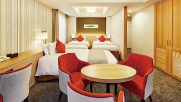 Une chambre d’hôtel avec deux lits, un bureau, une chaise, une table ronde et une armoire.