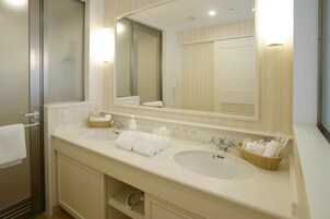 A hotel bathroom with two sinks, a large mirror, and a towel rack.