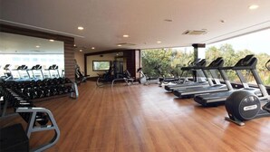 A gym with treadmills, ellipticals, and free weights. - Denissons (Hubli)