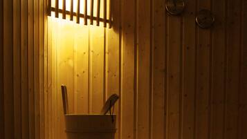 A wooden sauna with a bucket and a wooden bench.