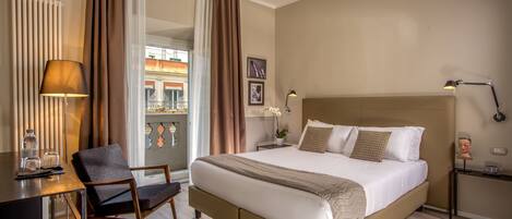 Une chambre d’hôtel avec un grand lit, un bureau, une chaise, une lampe et une vue sur l’extérieur.