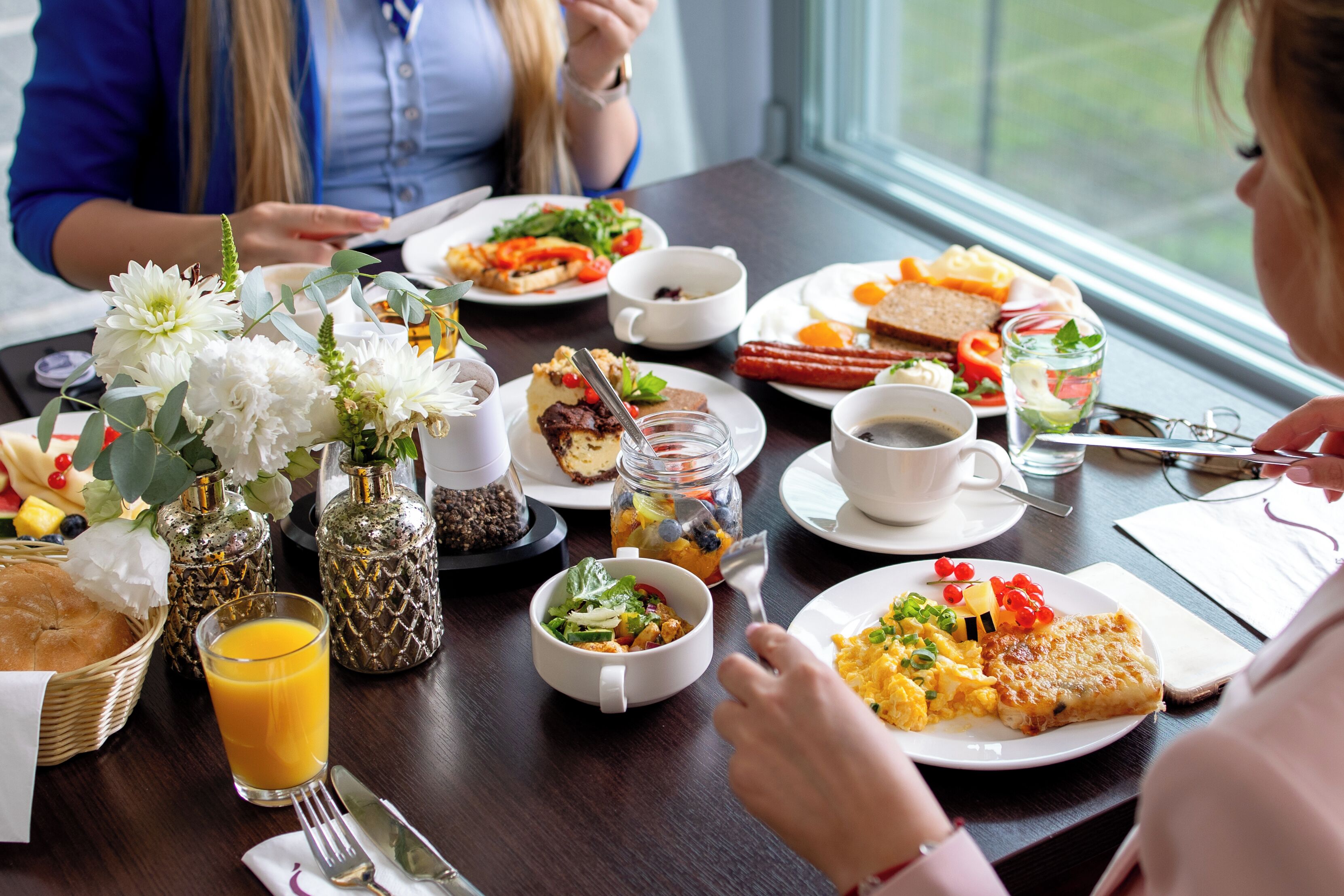 A dining table with various breakfast items, including eggs, toast, and a salad.