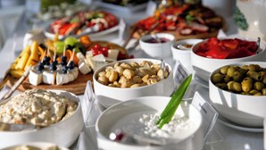 A buffet table with various food items including cheese, olives, and fruits.