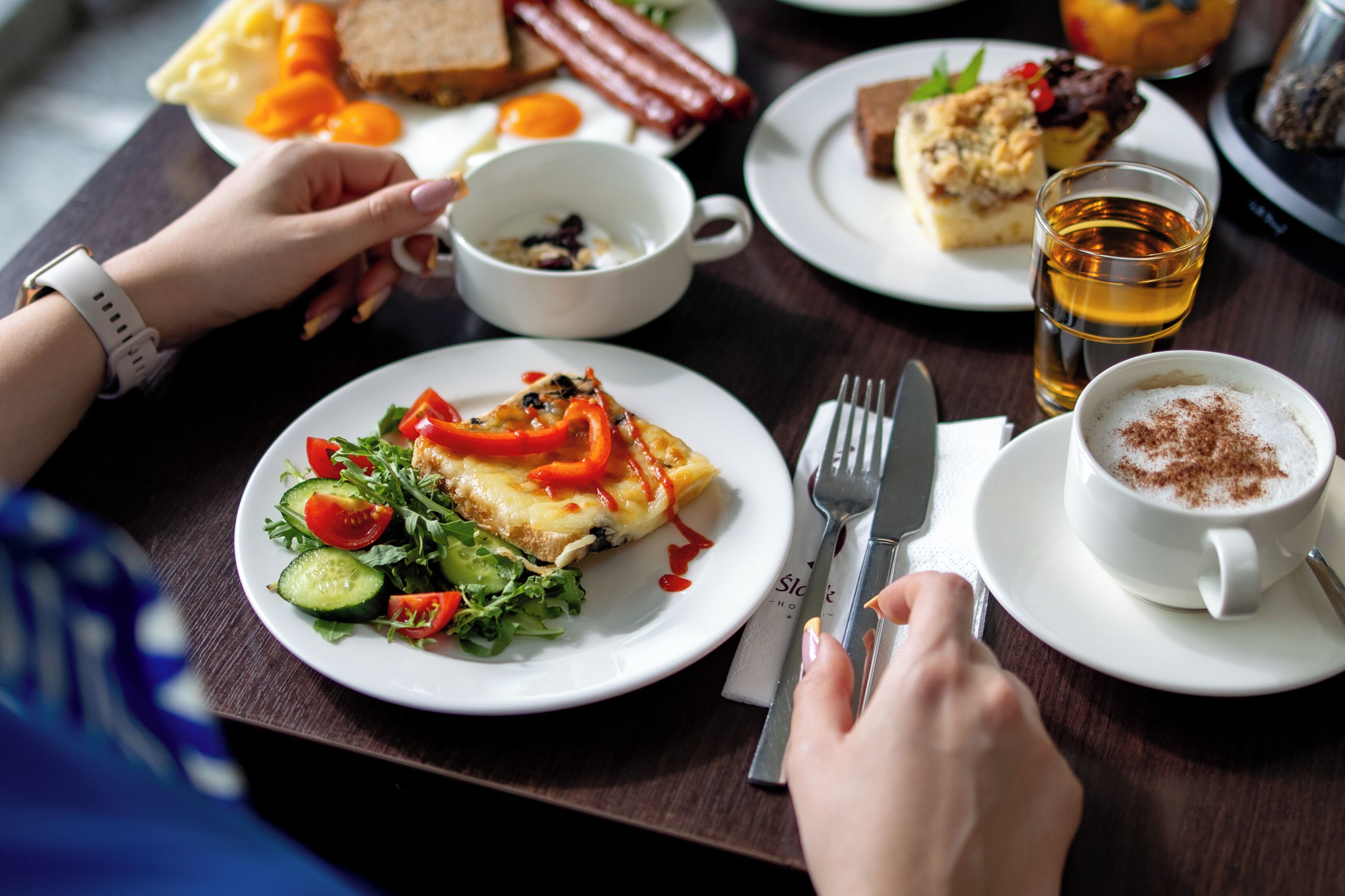 Ein Esstisch mit Tellern voller Essen, einer Kaffeetasse und einem Teeglas.