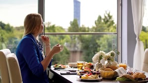 A dining table with a variety of food items and a person sitting at the table.