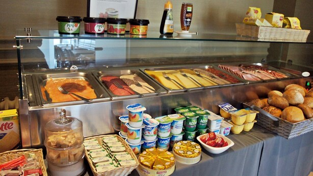 Een buffet met diverse gerechten, waaronder vleeswaren, kazen en zuivelproducten.