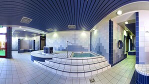 A modern indoor swimming pool area with a wooden wall, tiled flooring, and a central jacuzzi. - Hessen Hotelpark Hohenroda (Hohenroda)