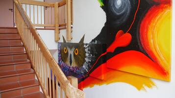 A staircase with wooden railings and a wall with a colorful abstract painting.