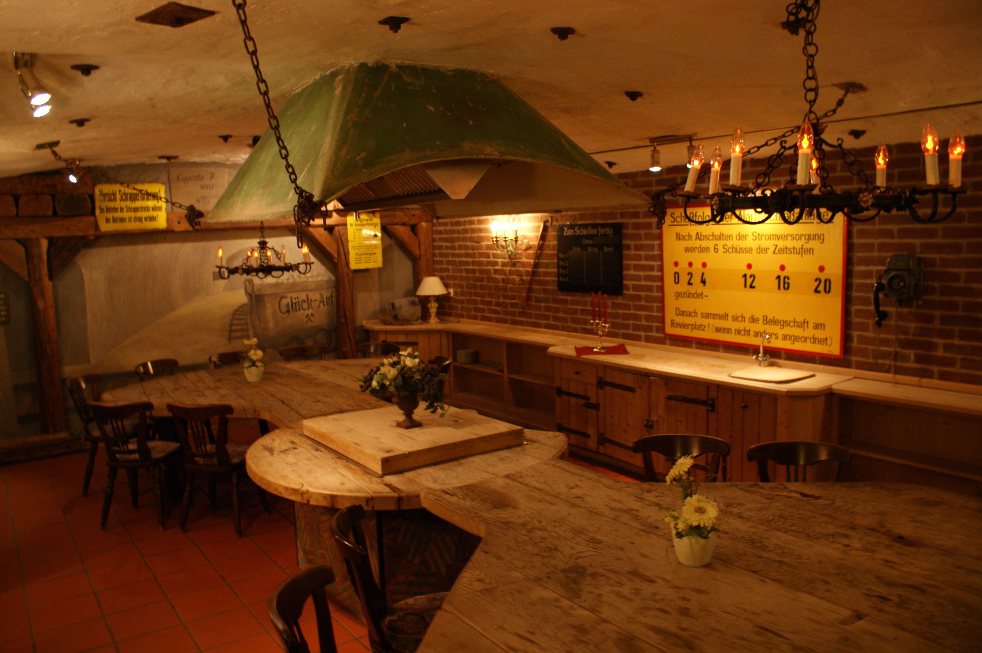 Un intérieur rustique avec une table en bois, des chaises et un luminaire suspendu.
