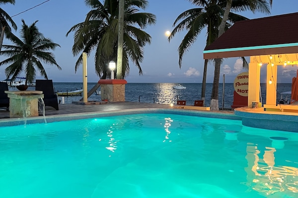 Alberca al aire libre, sombrillas en la alberca y camastros