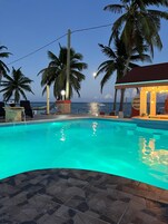 Una piscina al aire libre, sombrillas, tumbonas