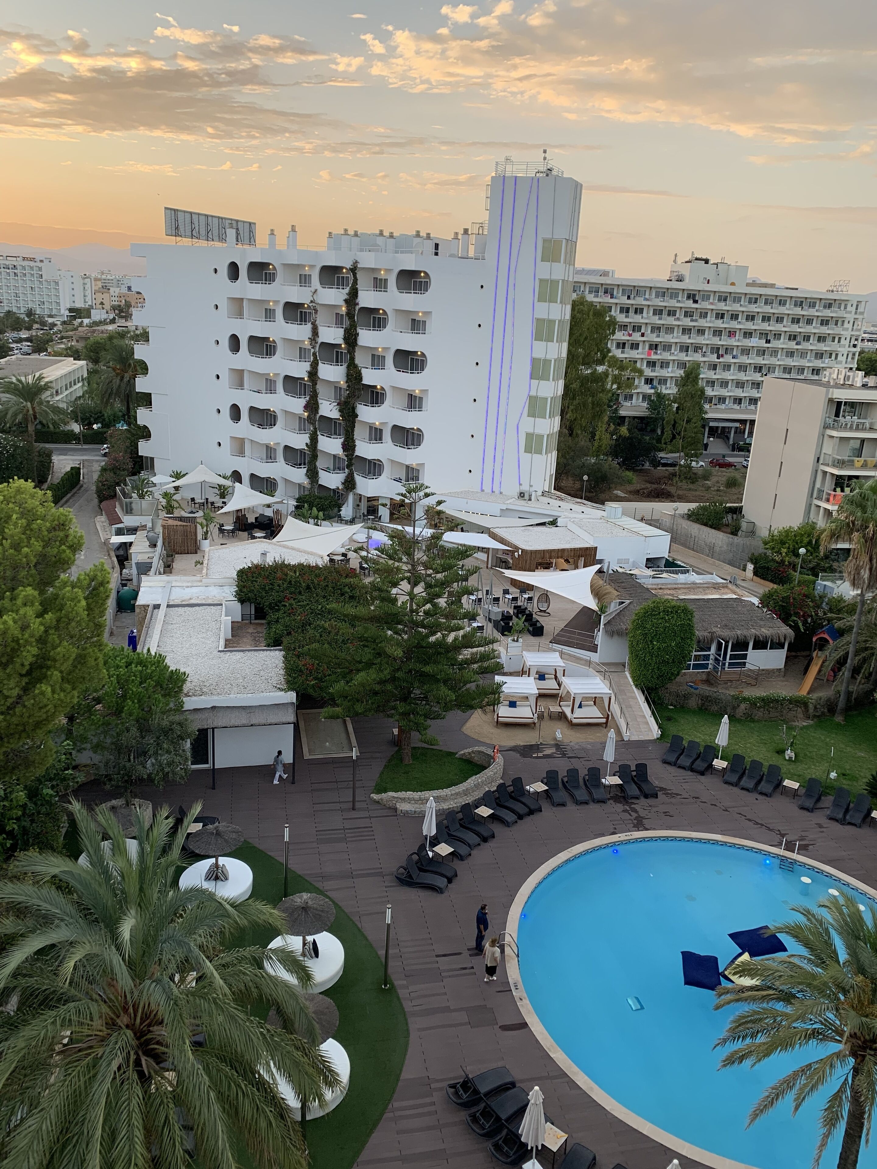 Ein Hotel mit Dachpool, Außenbereich und einem großen Gebäude mit mehreren Balkonen.