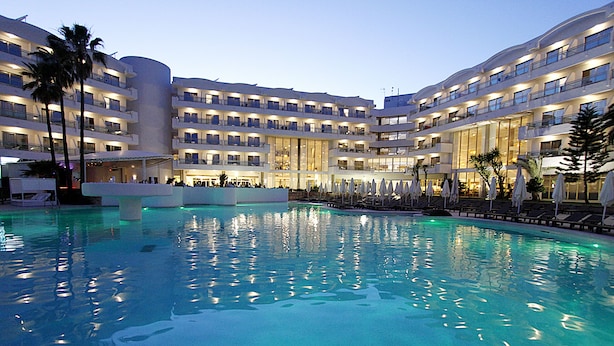A hotel with a central swimming pool, multiple balconies, and a modern architectural design.