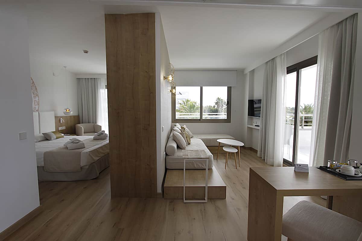 A modern living room with a sofa, a dining table, and a TV.