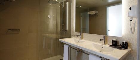 A modern bathroom with a glass-enclosed shower, a double sink vanity, and a large mirror.