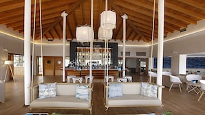 A spacious lobby with a high wooden ceiling, a bar area, and seating arrangements.
