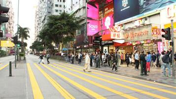 A busy urban street with pedestrians crossing a zebra crossing.