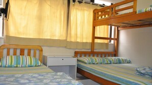 Habitación con literas, un escritorio pequeño y una ventana con cortinas.