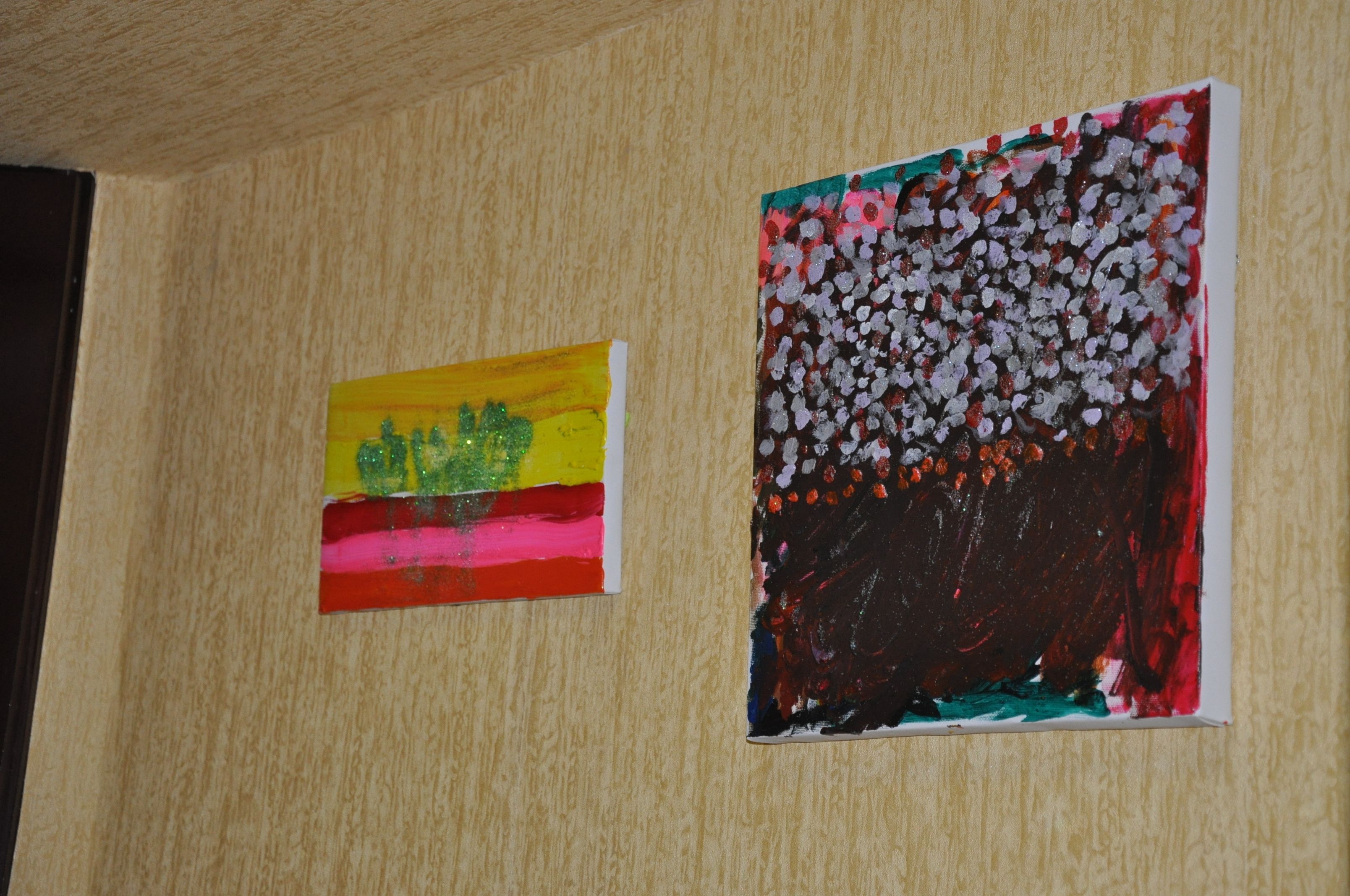 Deux tableaux accrochés à un mur en bois.