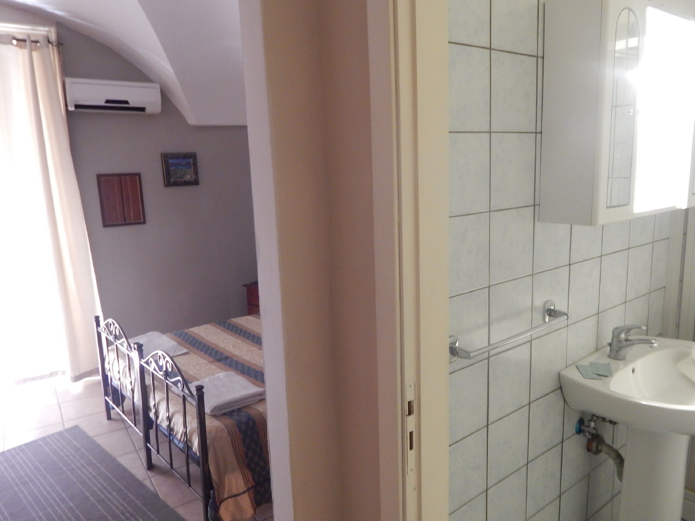Una camera da letto con un letto, un comodino e una finestra con tende.