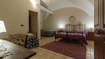 A bedroom with two beds, a dining table, and a chair.