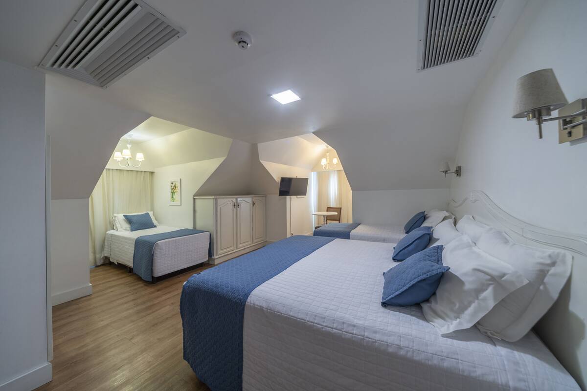 Un dormitorio con dos camas, un televisor y una mesita.