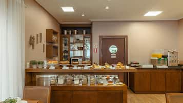 A breakfast bar with various food items and a coffee machine.