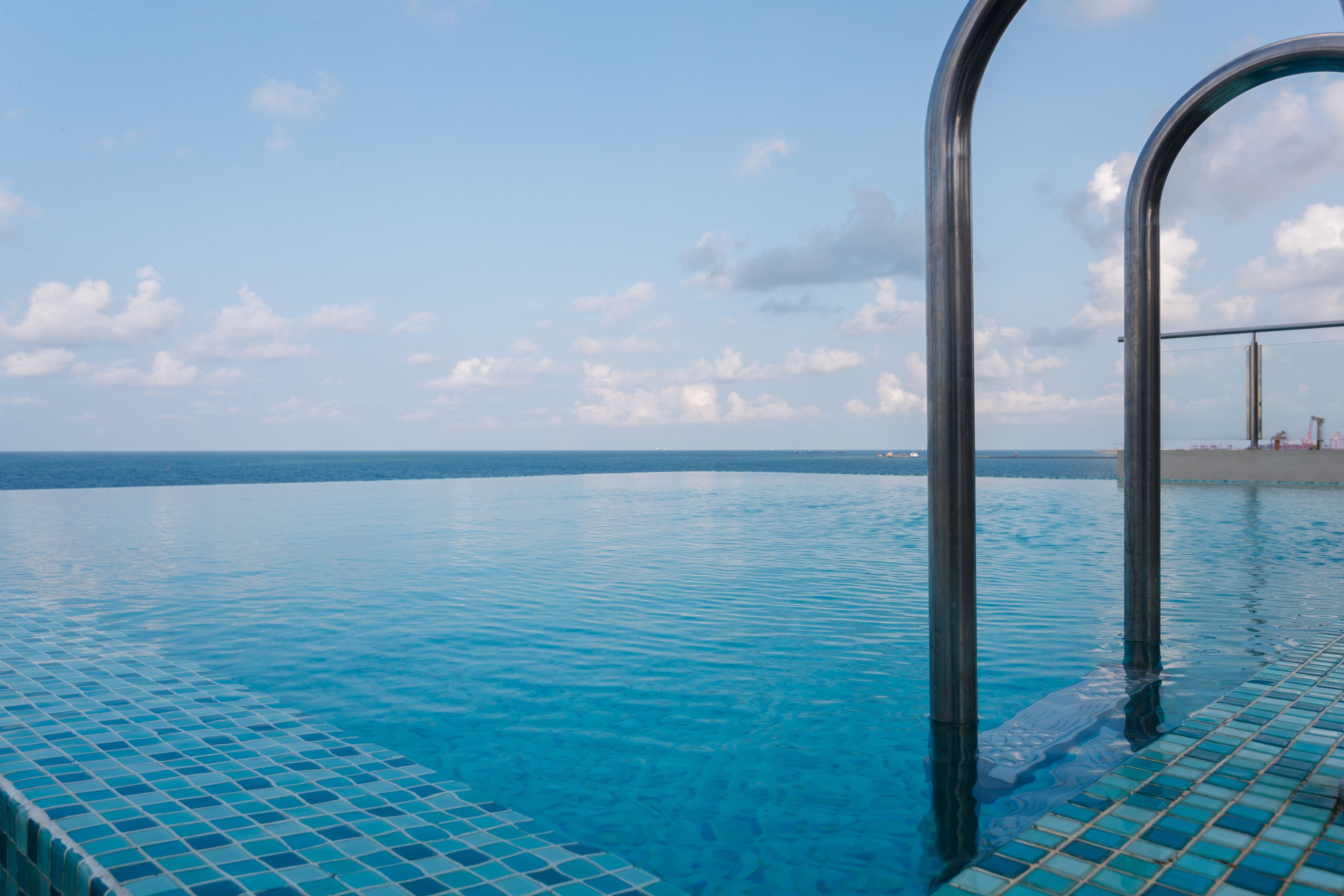A clear view of a swimming pool with a tiled edge and metal poolside structure.