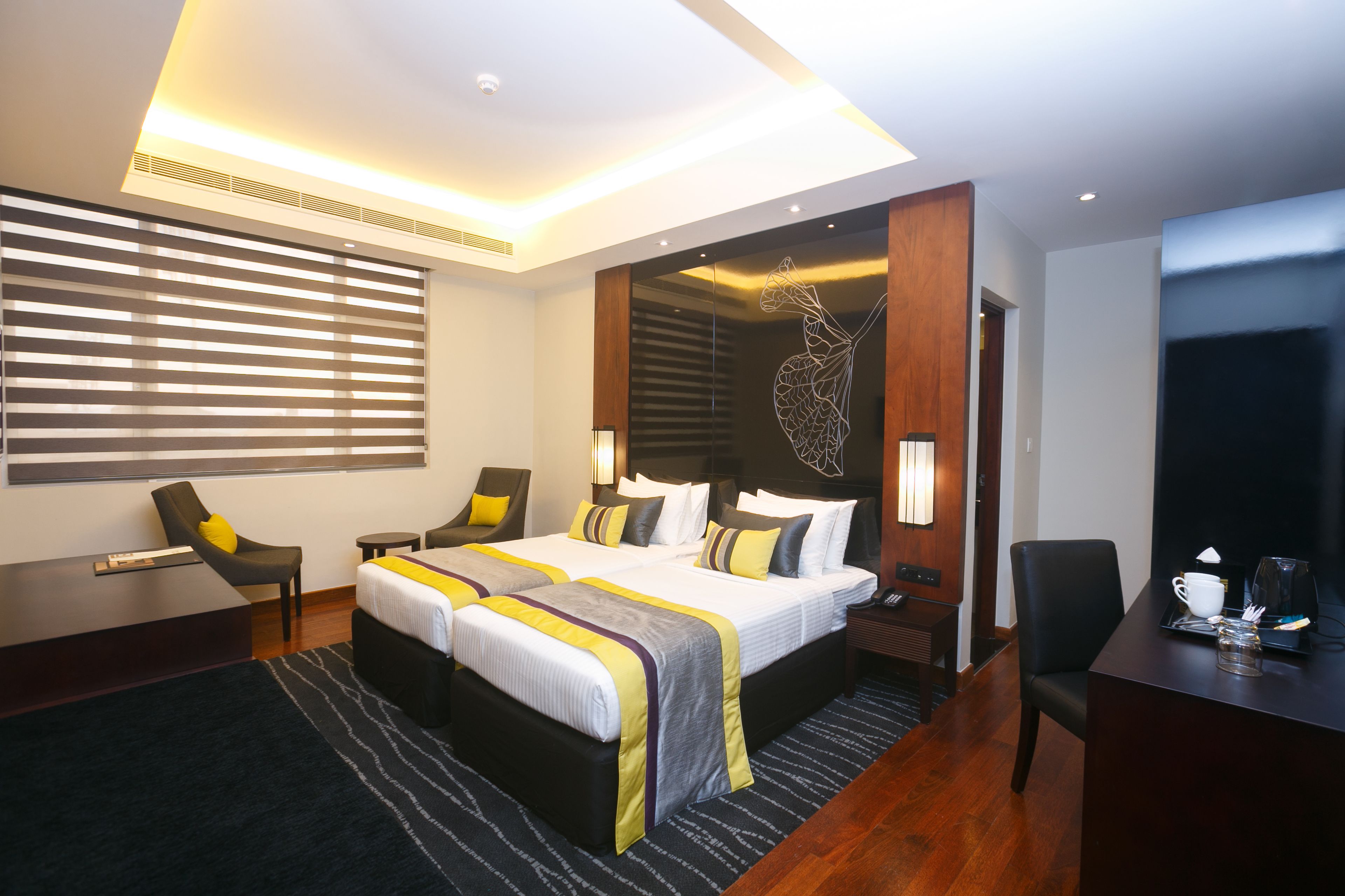 Una habitación de hotel moderna con una cama grande, mesitas de noche, un escritorio y una silla.