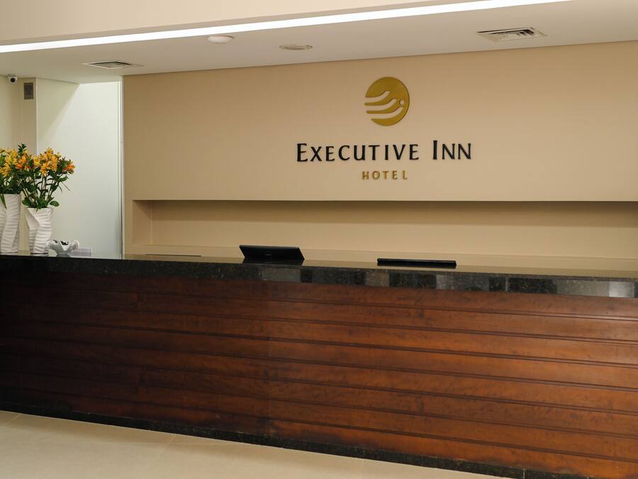 Un comptoir d’accueil à l’hôtel Executive Inn, avec un logo au-dessus.