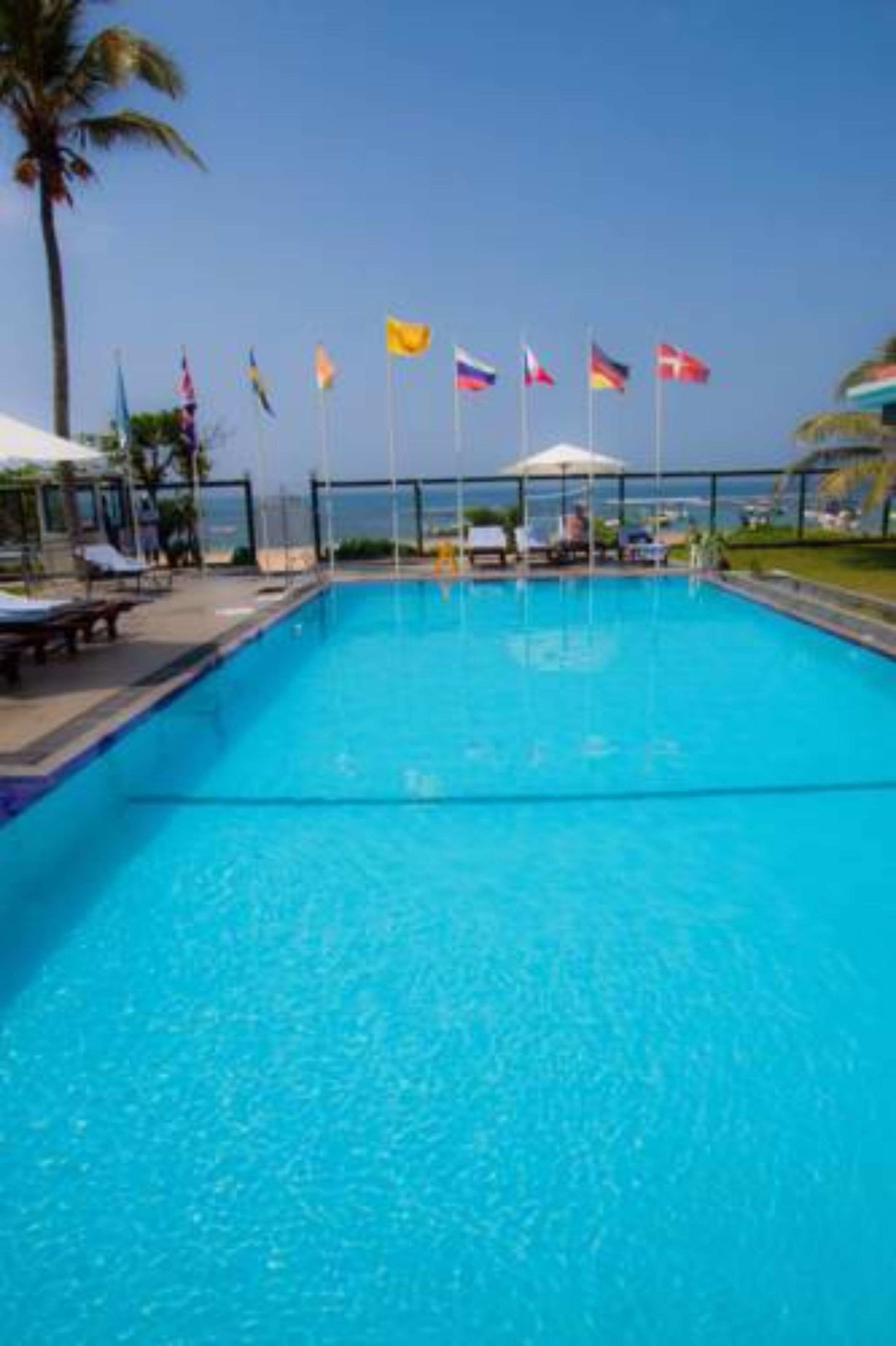 En swimmingpool med liggestole og flag.